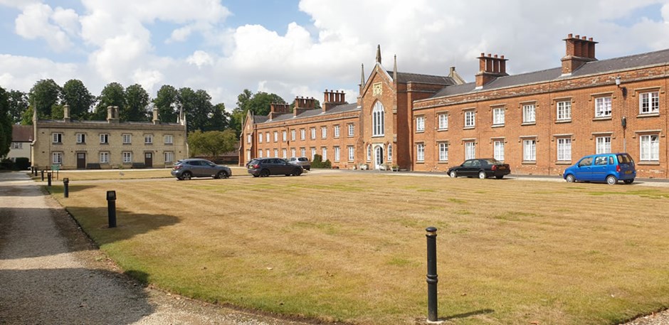 Vertically aligned windows and focal gables create an ordered compositionat almshouses in Saffron Walden